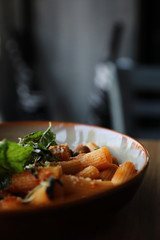 Pasta with sausage in tomato sauce on wood background , italian food