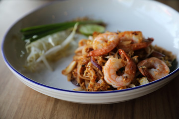 Pad thai with shrimp . Thai food on wood background