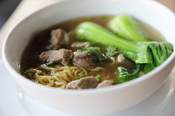 Chinese noodles with pork on wood background