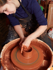 production process of pottery. Forming a clay mug on a potter's wheel.