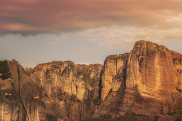 Landscape of monasteries of Meteora in Greece in Thessaly at the early morning. Cliffs of Meteora opposite a morning cloudy sky background