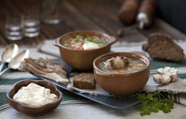 Close-up of tasty russian cabbage soup shchi in brown ceramic bowls on wooden table. Close-up, selective focus, shallow depth of field