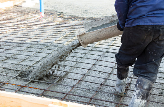 Closeup shot of concrete casting on reinforcing metal bars of floor in industrial construction site