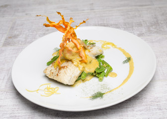 White fish baked with beans on a white plate