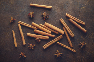 Cinnamon sticks and anise stars on the brown rusty backround.