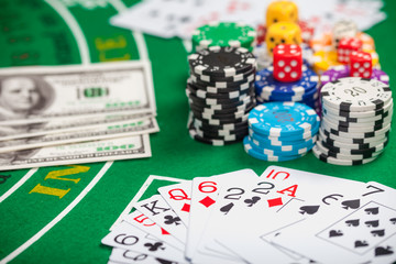 Poker chips on table in casino. Cards on green felt casino table