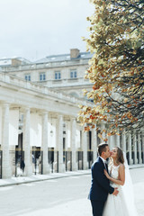 Obraz premium Stunning newlyweds look luxury posing in classy dresses on the streets of romantic Paris