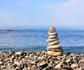 Fototapeta na wymiar Pyramid of stones on a background of sea and sky