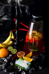 Red hookah with orange and with a box of tobacco and a place for your design on a black background