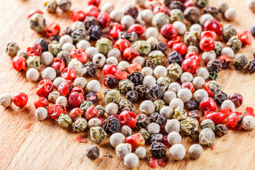The pepper mix on a wooden background