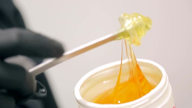 Girl in black gloves takes sugar for a sugaring