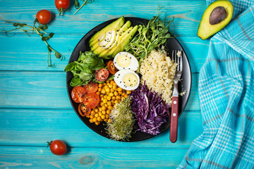 Healthy vegan lunch bowl. Vegan buddha bowl. Vegetables and nuts in buddha bowl on blue wood...