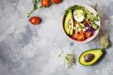 Healthy vegan lunch bowl. Vegan buddha bowl. Vegetables and nuts in buddha bowl on concrete background. Top view