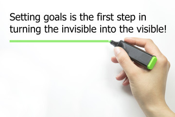 Women Hand writing Setting goals is the first step in turning the invisible into the visible with...