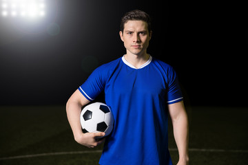 Footballer standing on football green