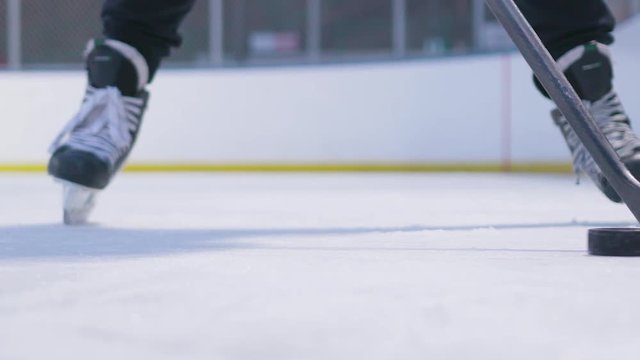Slow motion action shot of a hockey player stick handling with a puck while standing on the ice