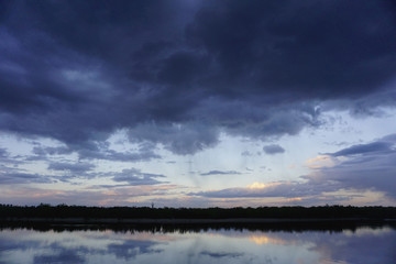 Landscape with forest and amazing sunset blue clouds reflected in river Dnieper, Kiev, Ukraine. 