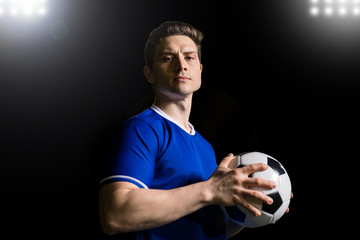 Portrait of a soccer player on a stadium with football