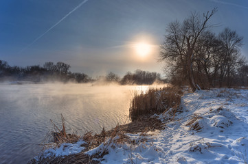 Winter sunset landscape with foggy river.