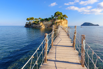 Wooden bridge from Agios Sostis leading to small rocky island. Bay of Laganas, Zakynthos island, Greece.