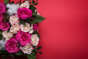 Beautiful roses to a small karzinka on a red background