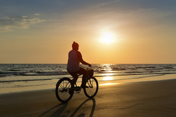 Fototapeta premium Silhouette of young woman cycling.