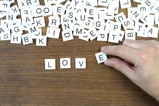 " Love " writing with plastic letters on a wooden table. Conceptual image.