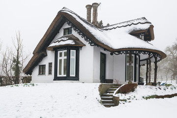 Winter snow covered thatched cottage in England