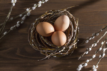 three eggs in a nest on a wooden background Easter top spring Holy Christian holiday