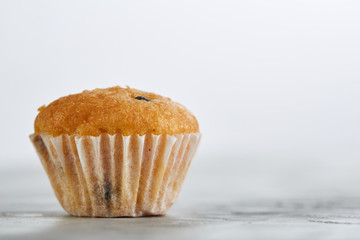 Tasty muffins arranged in pattern on light textured background, close-up, shallow depth of field, selective focus.