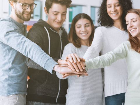 Young people stacking hands