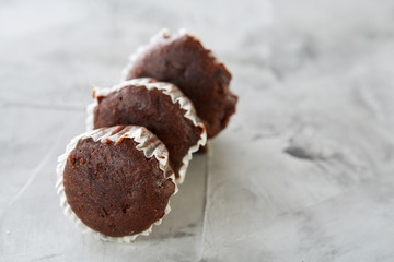 Tasty muffins arranged in pattern on light textured background, close-up, shallow depth of field, selective focus.