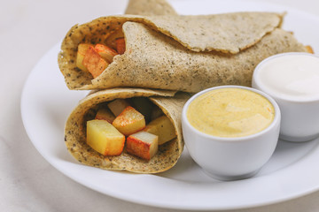Vegetarian masala dosa with potato, chutney and sambar sauces.
