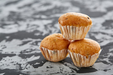 Tasty muffins arranged in pattern on light textured background, close-up, shallow depth of field, selective focus.