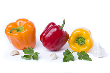 Red yellow and orange peppers on a white background..Multicolored vegetables in a composition on an abel background.