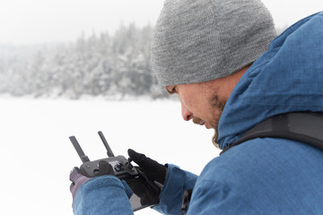 Young man flying a drone in winter