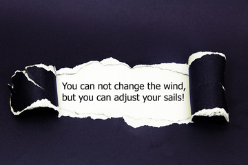 Motivational quote You can not change the wind but you can adjust your sails, appearing behind torn...