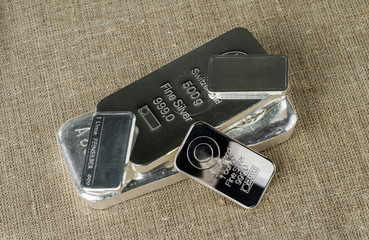 Several silver bars against the background of the texture of coarse cloth. Feinsilber is fine...