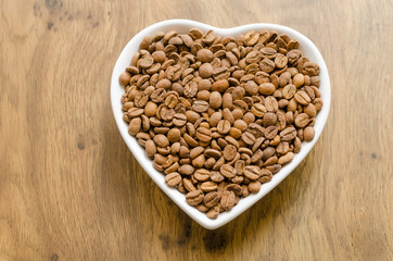 coffee beans in a white heart-shaped plate
