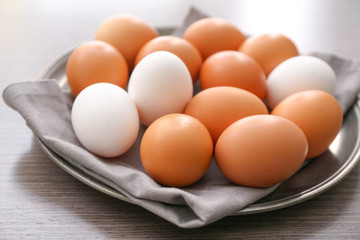 Plate with chicken eggs on table, closeup