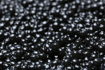 Delicious black caviar as background, closeup