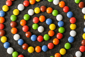 Colorful candies on grey background, flat lay