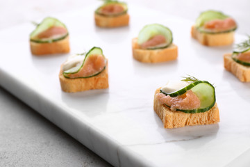 Tasty appetizer with codfish caviar on marble board, closeup