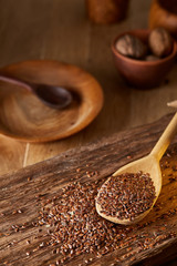 Wooden spoon with flax seeds on rustic background, top view, close-up, shallow depth of field, selective focus