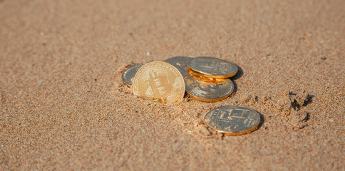 Fototapeta na wymiar bitcoin on the sand by the sea
