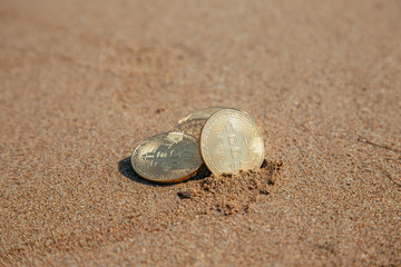 Fototapeta na wymiar bitcoin on the sand by the sea