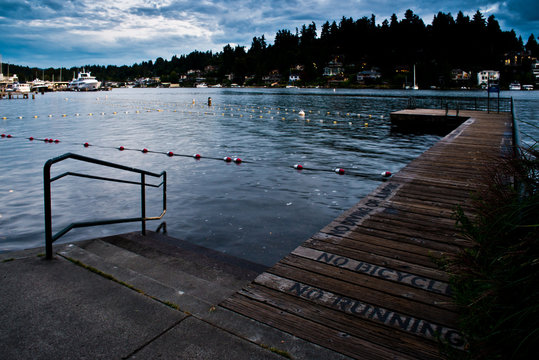 The Lonely Pier At The Swimming Lanes At Meydenbauer Beach Park In Bellevue After Hour After Dark, the sunset is fading in the background as the night taking over.