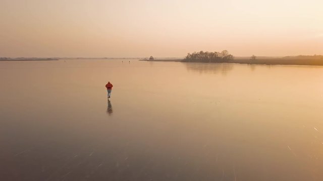 A man is skates on a natural frozen lake in the Netherlands.