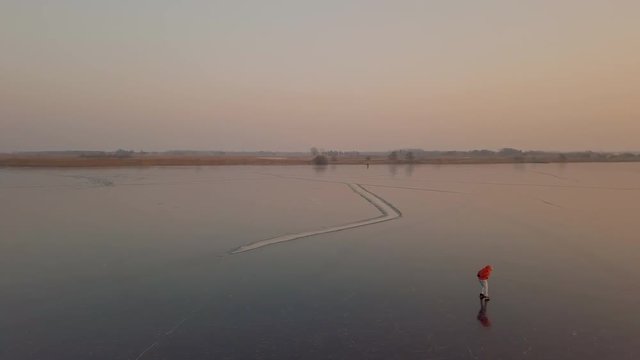 A man is skates on a natural frozen lake in the Netherlands.