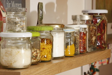 bunte gewürzgläser auf küchenbrett